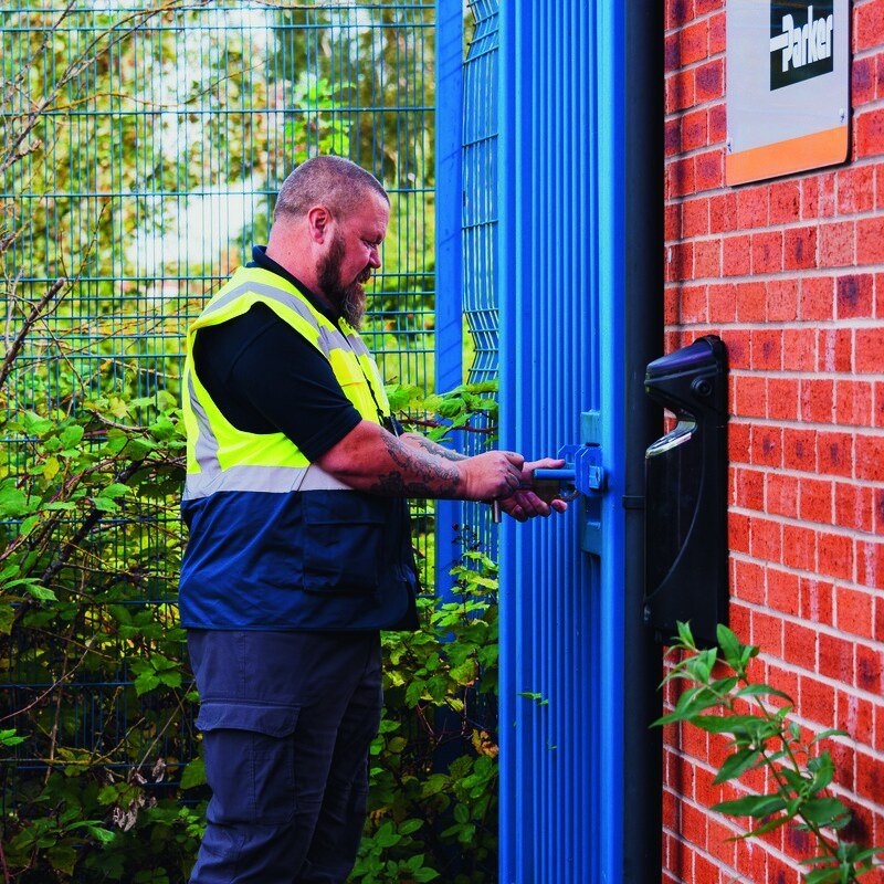 NVC officer checking a door at a brick building